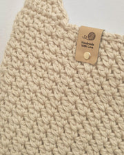 Beige handgehäkelte Schultertasche aus Baumwolle mit strukturierter Oberfläche und langem Träger
