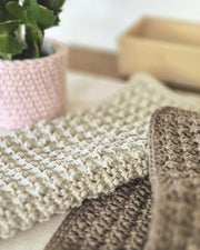 Zwei gehäkelte Baumwolltücher in Steingrau und Taupe, jeweils 25 × 25 cm